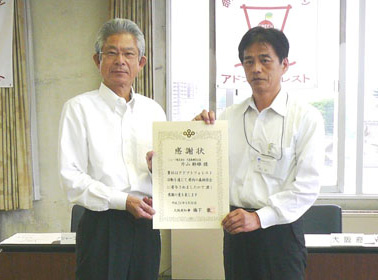 表彰状を手にするCSR推進本部 後藤本部長(左)と西山 大阪府みどり・都市環境室長