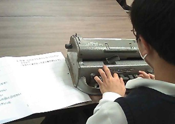 点字タイプライターを使いワークシートを記入する生徒