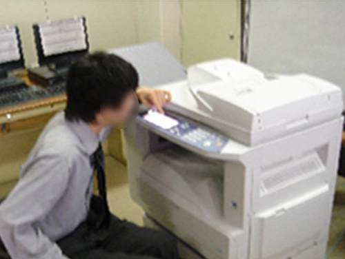 車いすを利用されているモニターの職場でモニターが複合機を使っている様子