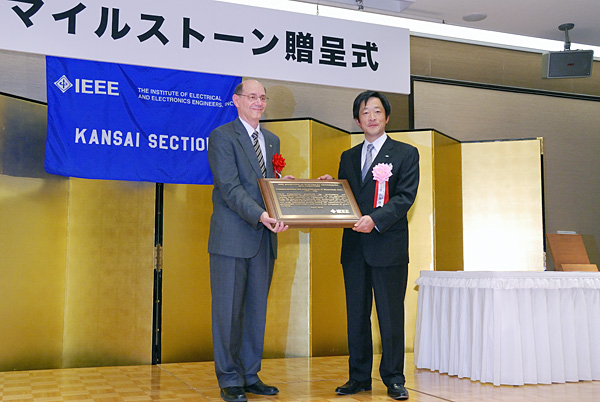 IEEEより贈呈された記念の盾を受け取る 代表取締役社長　かた山 幹雄